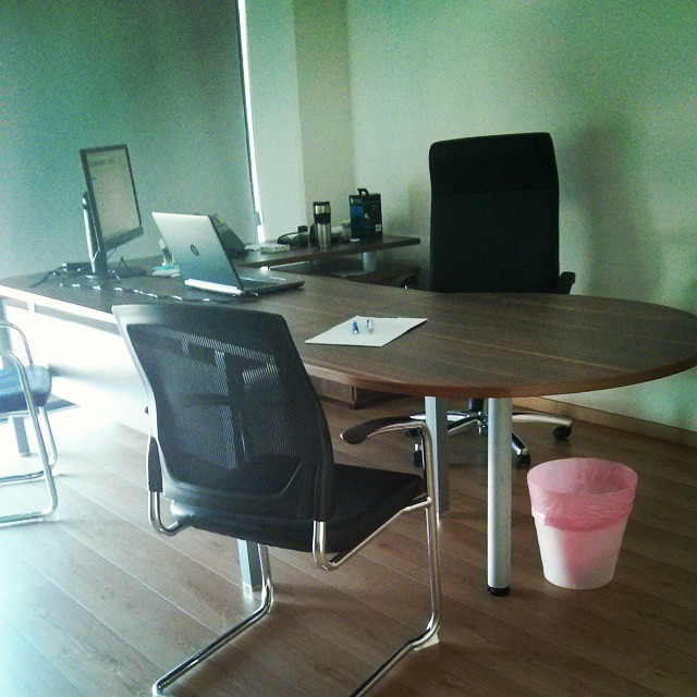 a table and chairs in an office setting with light colored hardwood flooring