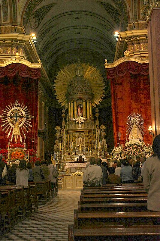 the people are in the cathedral waiting for the priests to perform