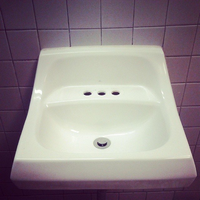 a white bathroom sink with an attached faucet