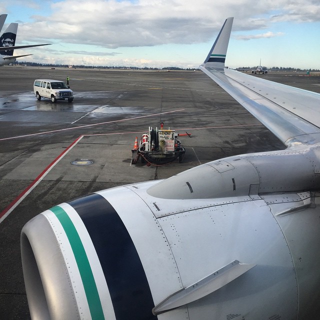 an airplane engine sitting on the tarmac as another vehicle approaches