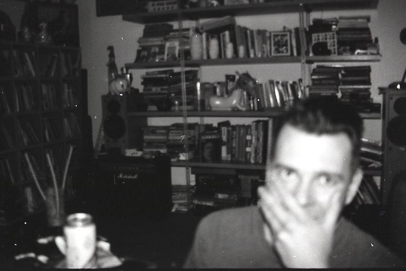 a black and white image of a man in front of books