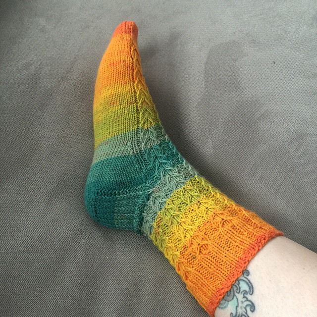 a person with two colorful socks on their legs