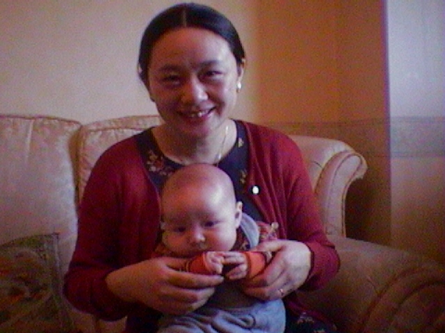 a woman holding a baby and smiling at the camera