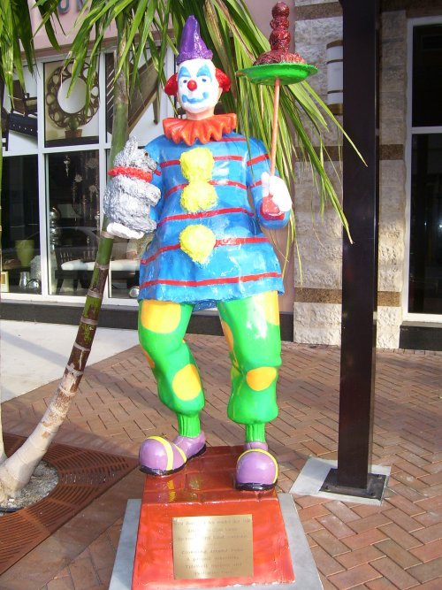 there is a colorful clown statue on a pedestal