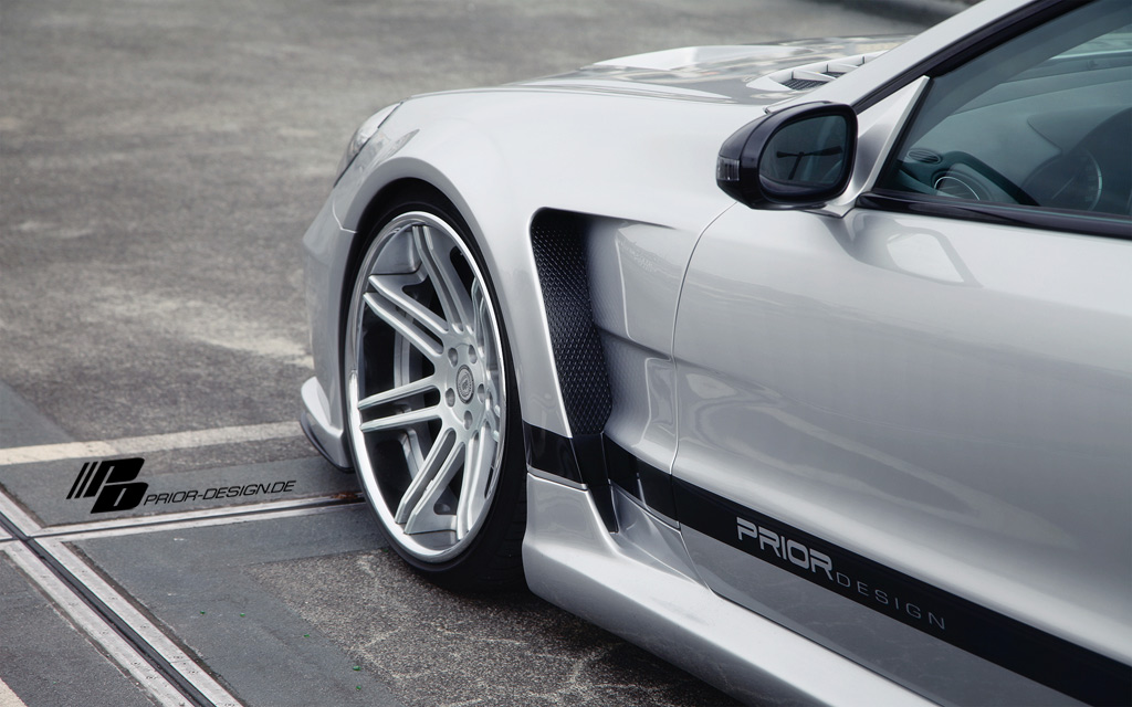 silver colored sports car with chrome rims parked next to the side of the street