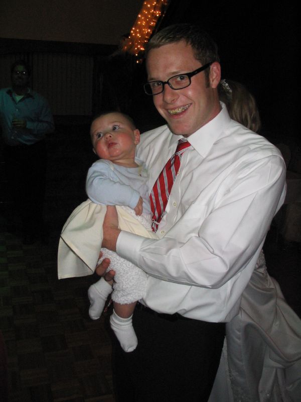 the man in glasses is holding his baby