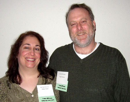 a woman smiling next to a man with glasses