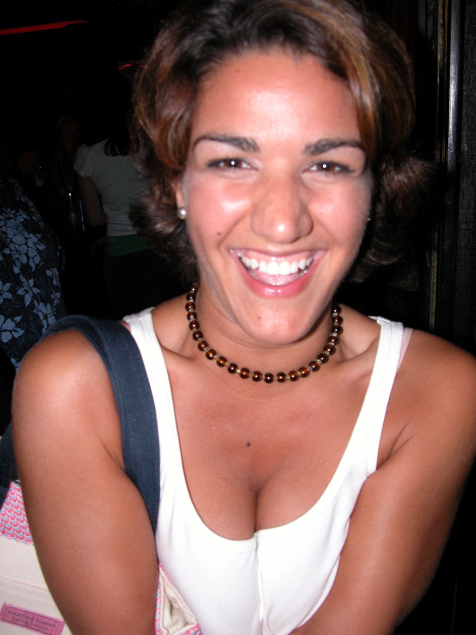 a woman wearing a brown necklace with a small black bead around her neck