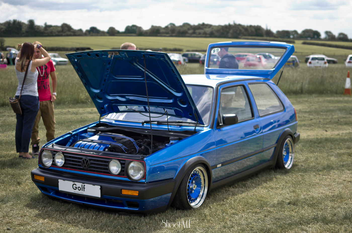 blue automobile is parked with its hood open at the event