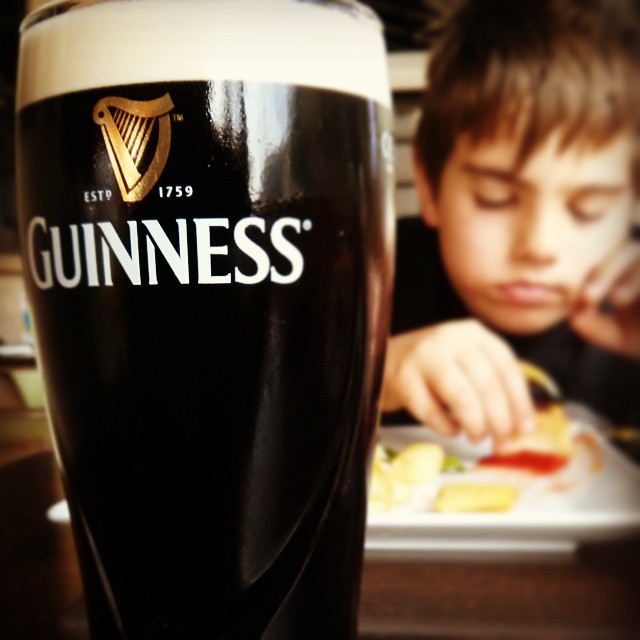 a  eating and drinking from a guinness glass