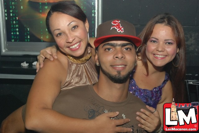 three people in a club smile for the camera