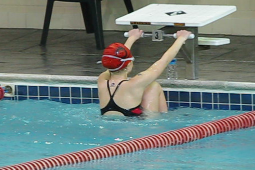 a woman in a swim suit and red helmet holding a paddle