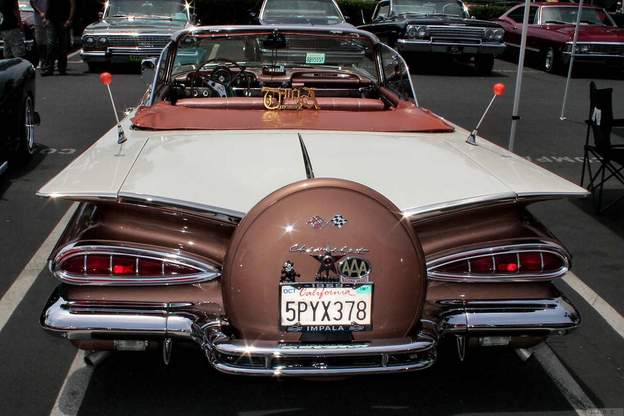 a classic car in a parking lot at an auto show