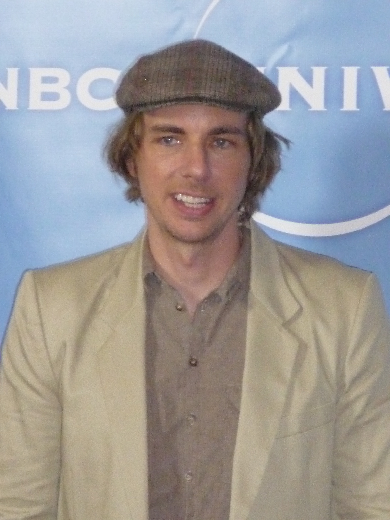 man wearing brown suit and brown hat smiling for camera