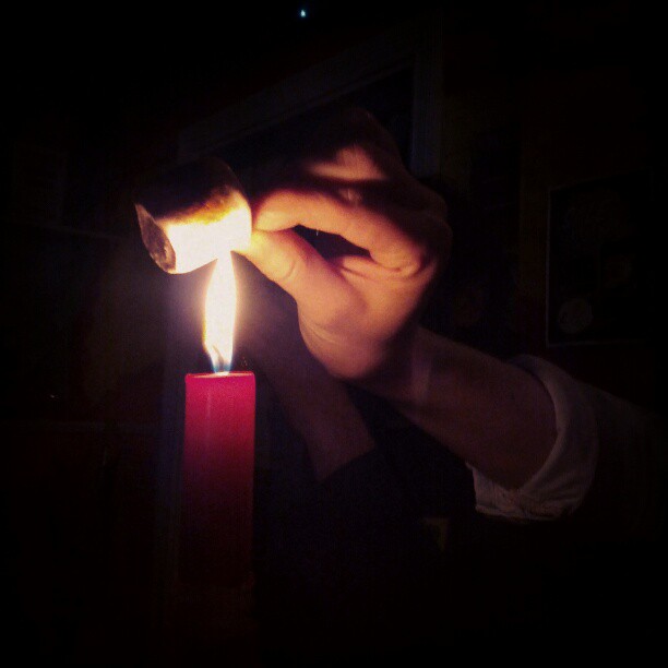 a person lighting a candle with a lighter stick