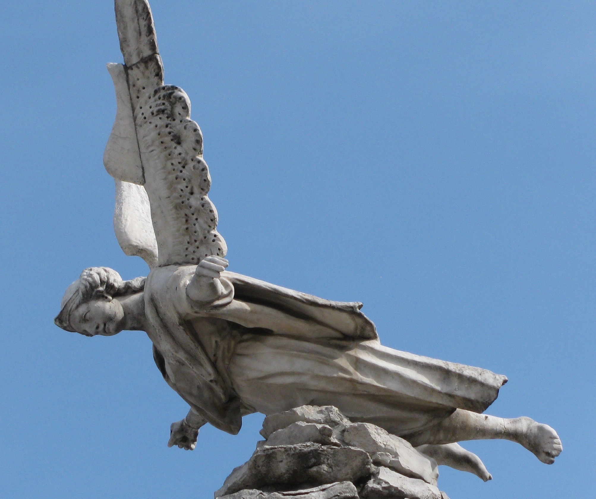 a statue has a long bird in its mouth