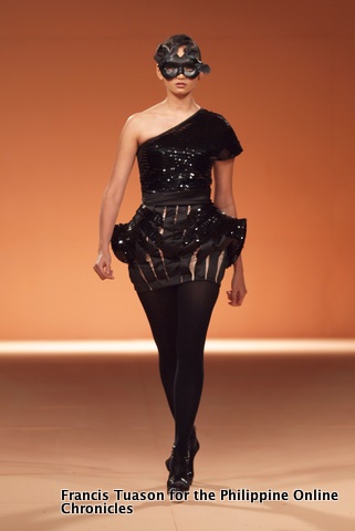 a woman in a short dress walking on the runway