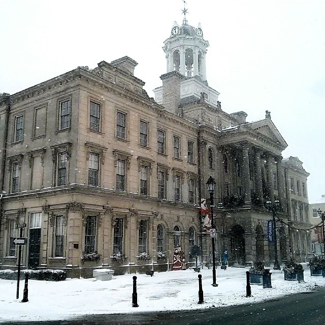 a large building with a clock tower is on the corner of the street