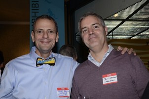 two men wearing matching bow ties standing side by side