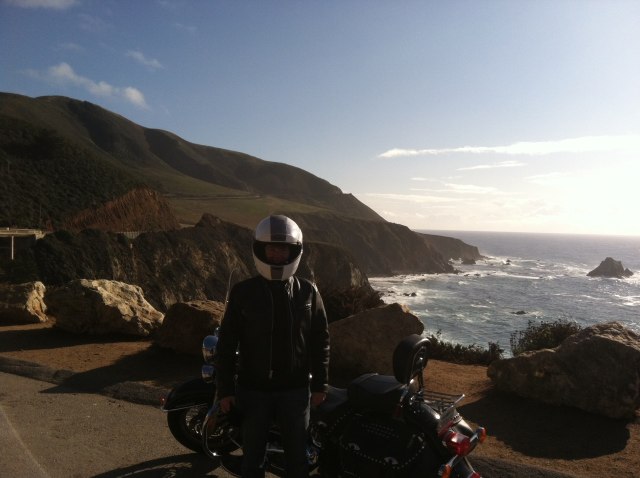 a person wearing a helmet next to a parked motorcycle