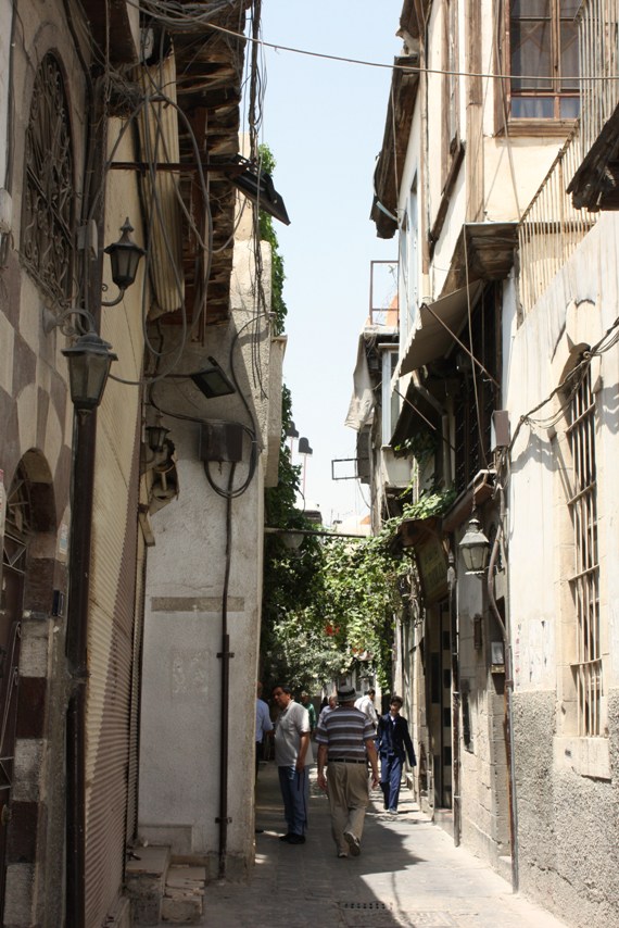 people walk on the narrow street in the old city