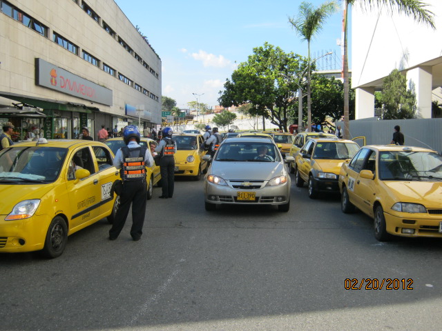many taxis are on the street in front of tall buildings