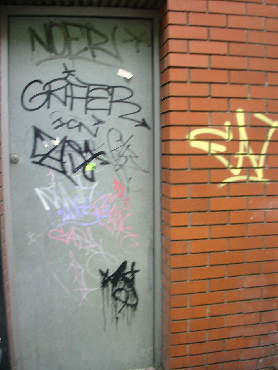 graffiti written on a door on the side of a building