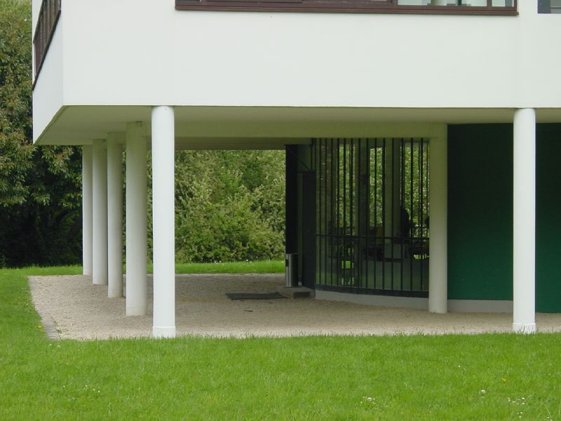 a white building with a green door and green grass