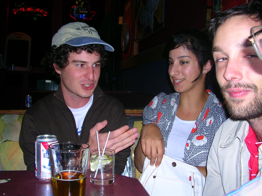 three friends having drinks and a conversation at a cafe