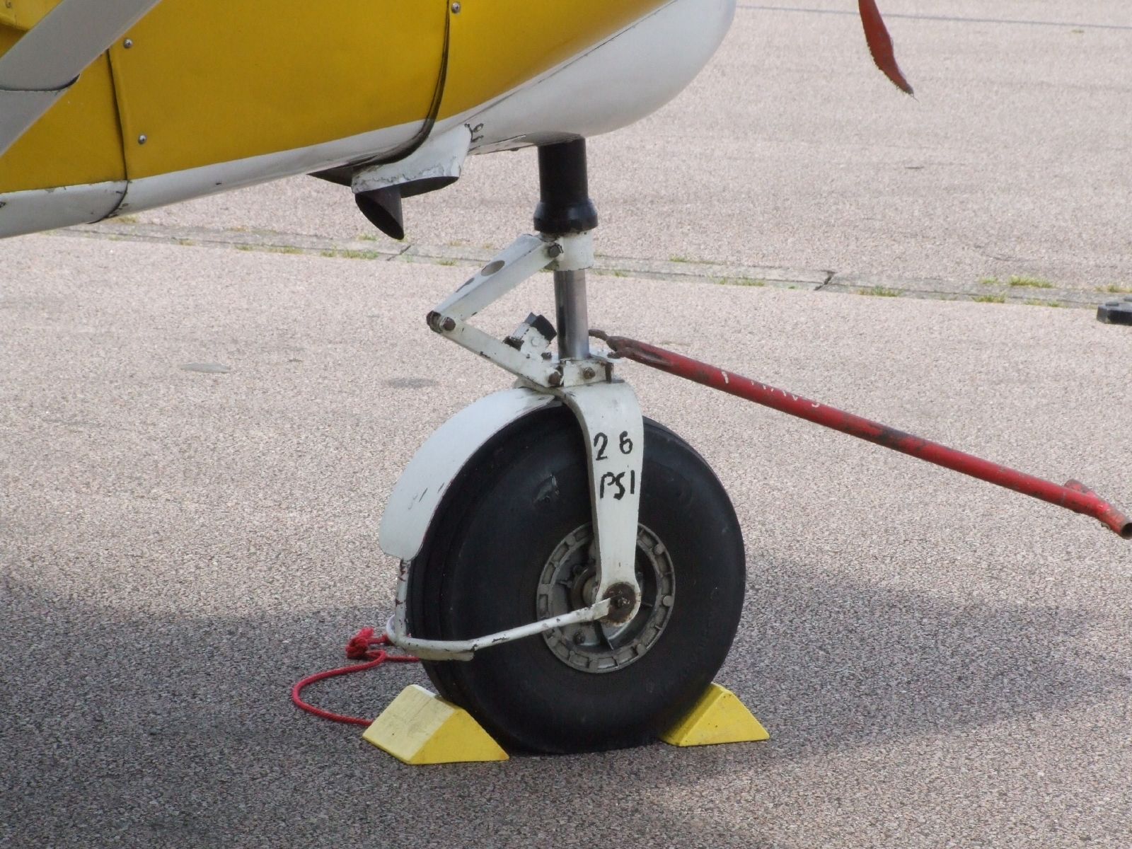 a yellow airplane with its landing gear down on the runway