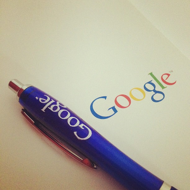 a pen on top of a paper and the google logo