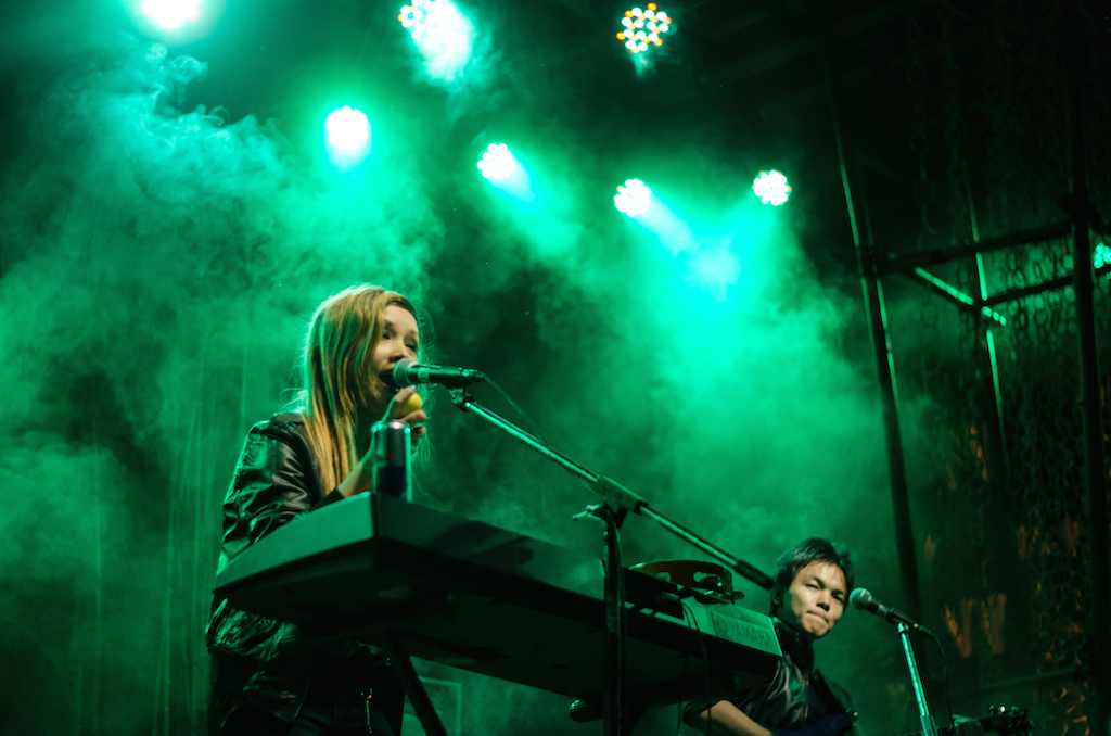 two women playing instruments and singing on stage