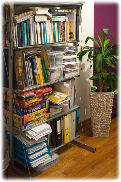 a metal bookcase with many books, books and files