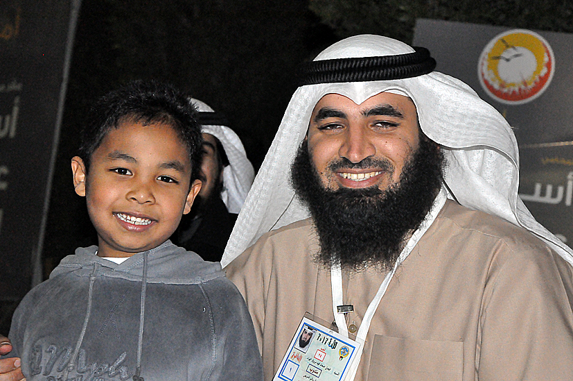 two young men pose for the camera in front of a backdrop