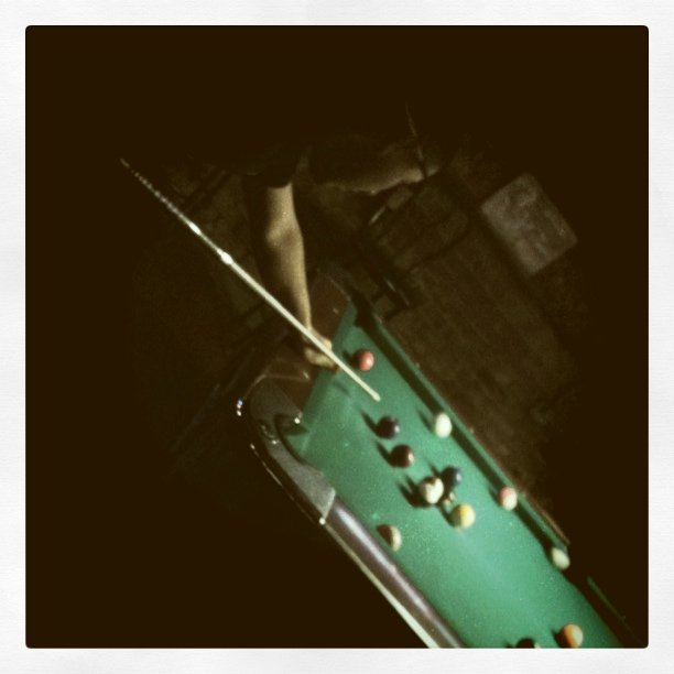 a pool table filled with a billiard's cue and lots of balls