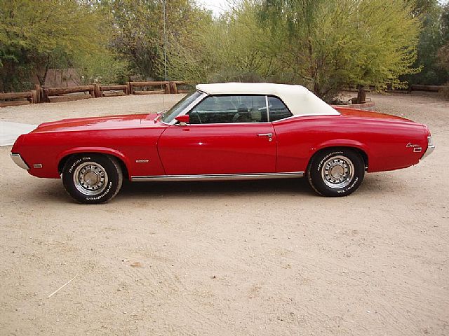 an old classic red car parked in the driveway