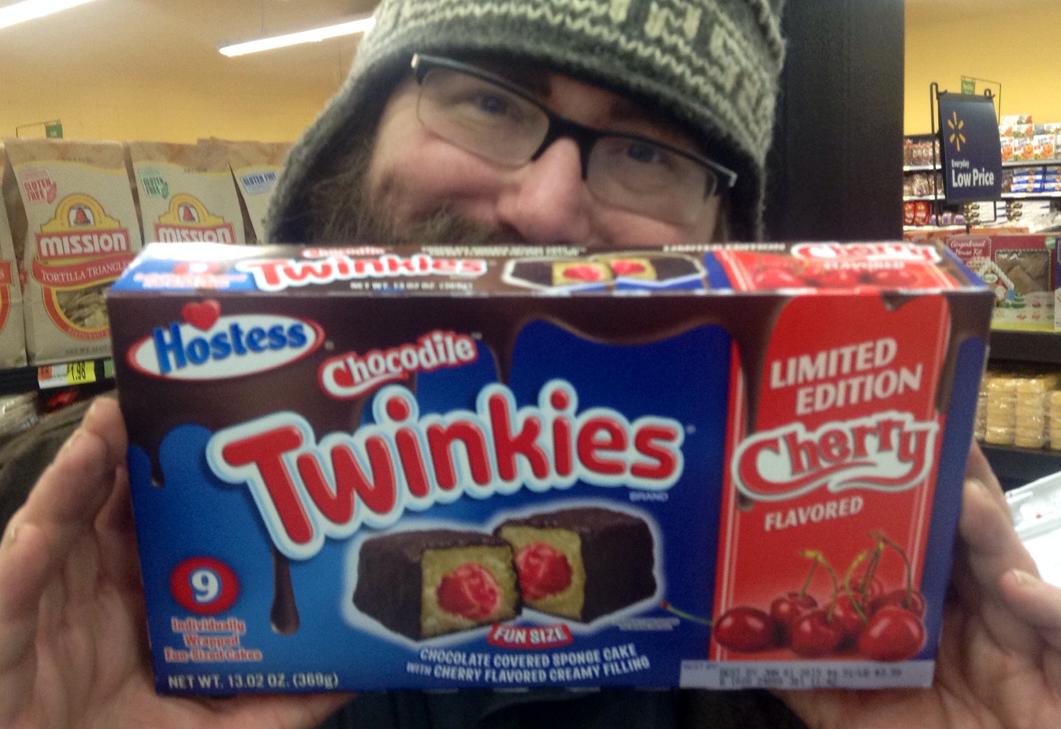 a man in a hat is holding up a box of twinkies