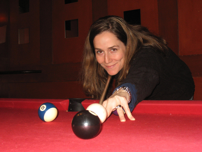 a woman is leaning over a pool table