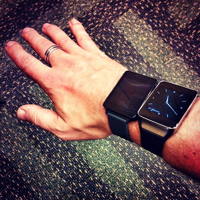 a hand holds onto a smart phone with a watch