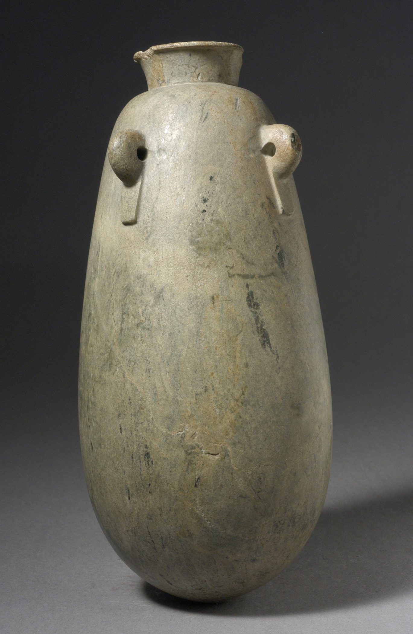 a gray vase sitting on a gray surface