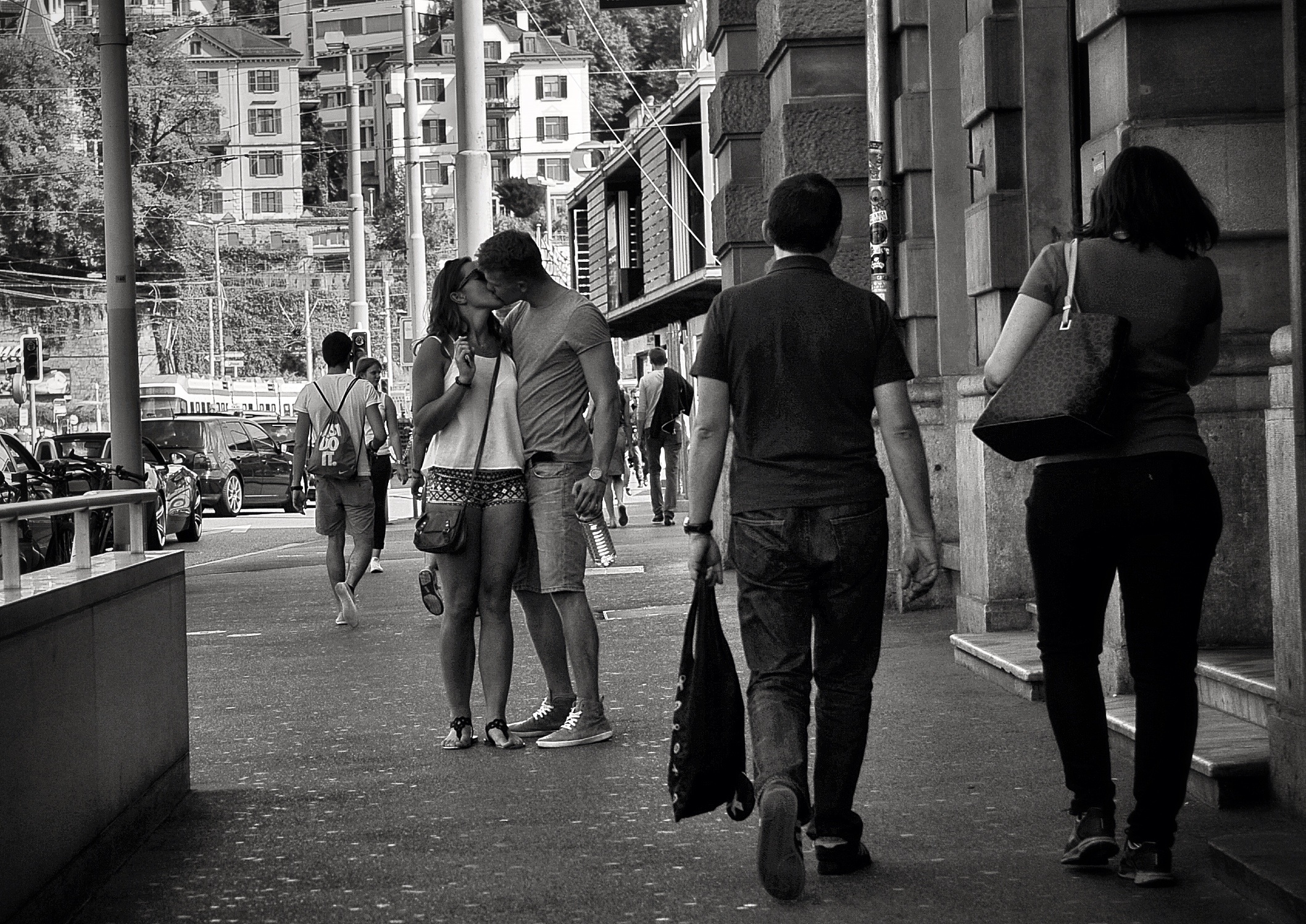 two people walking on the sidewalk by some buildings