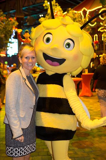 a woman is standing next to a big bee mascot