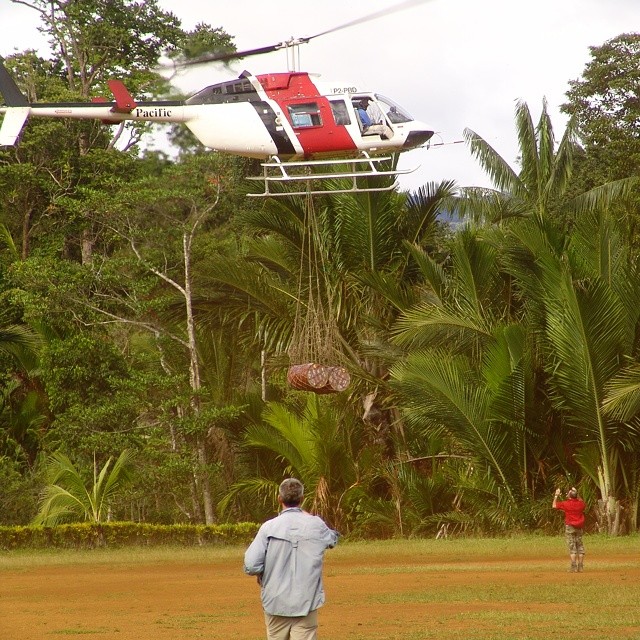 a man watching a helicopter fly over him