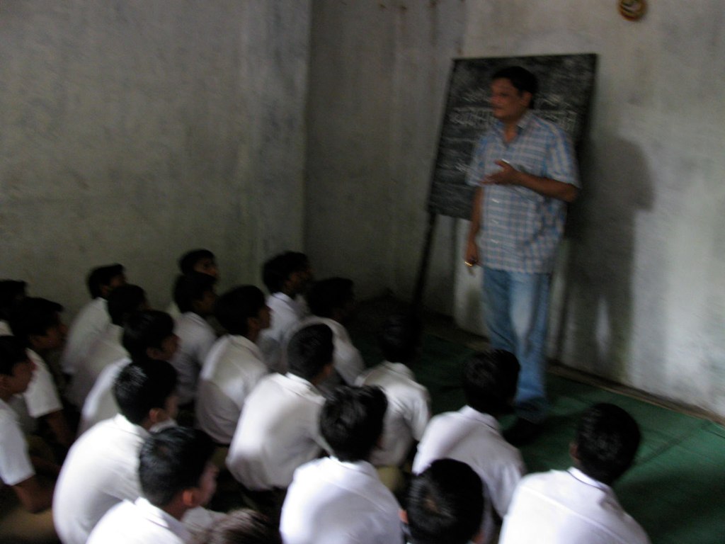 man teaching a class of men in white shirts