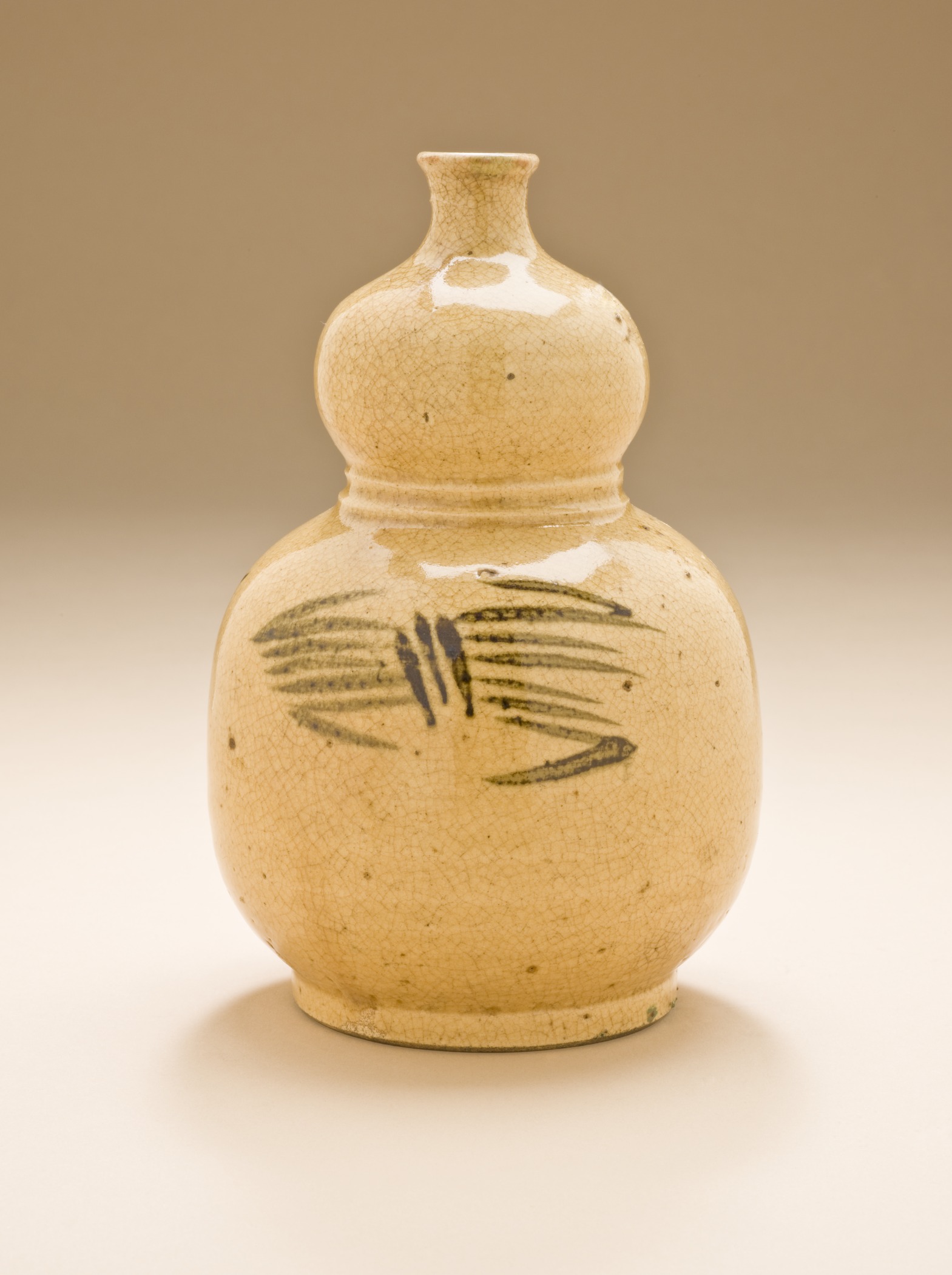a beige vase with an artistic palm leaf pattern