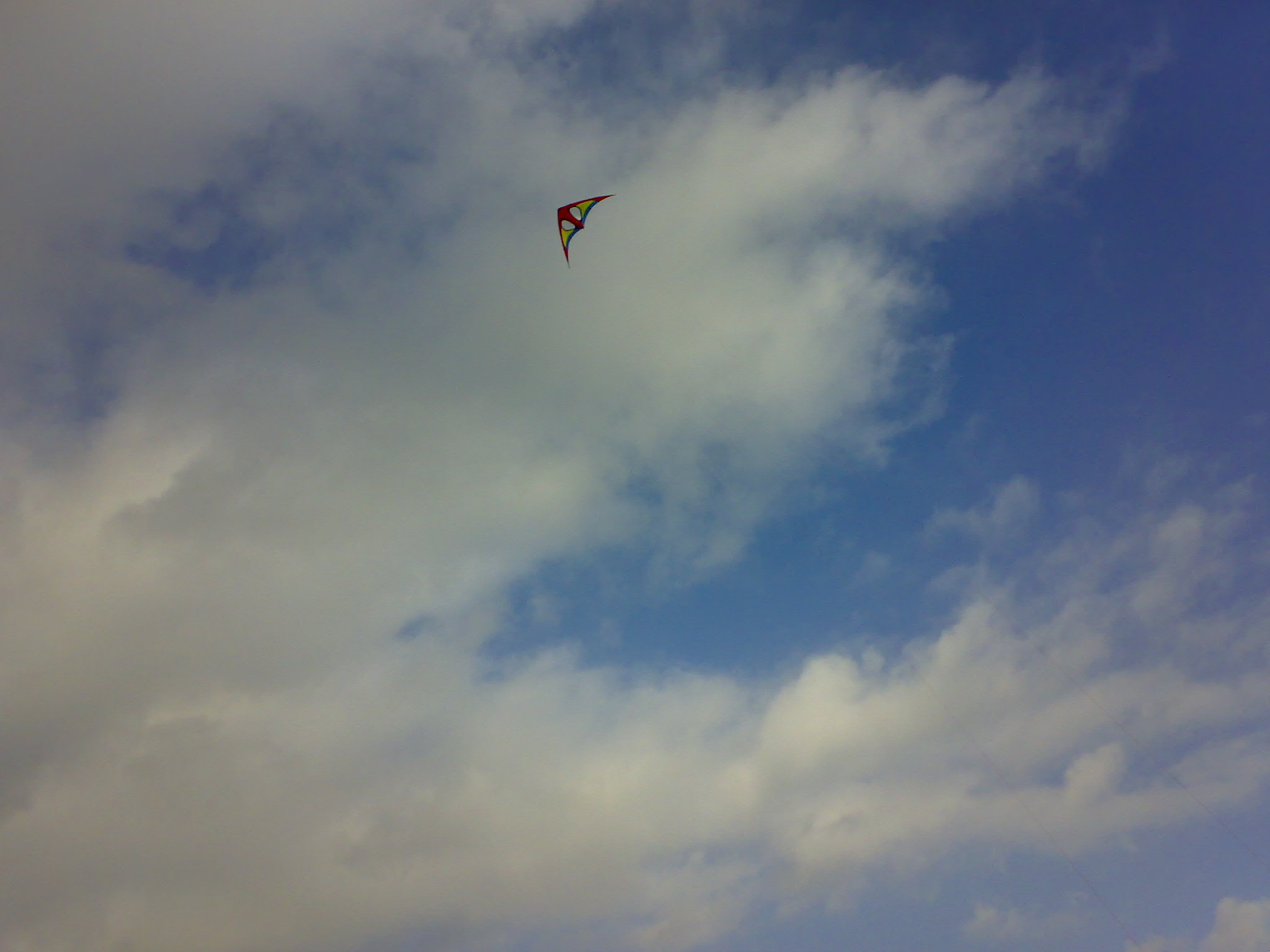 a kite flying in the sky with clouds