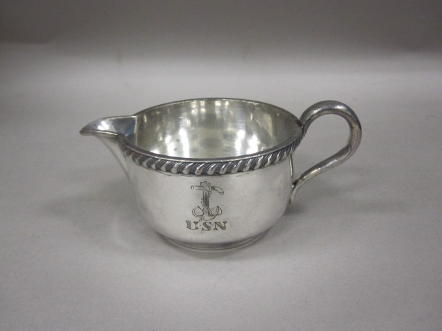 a small silver saucer with the handles engraved with initials