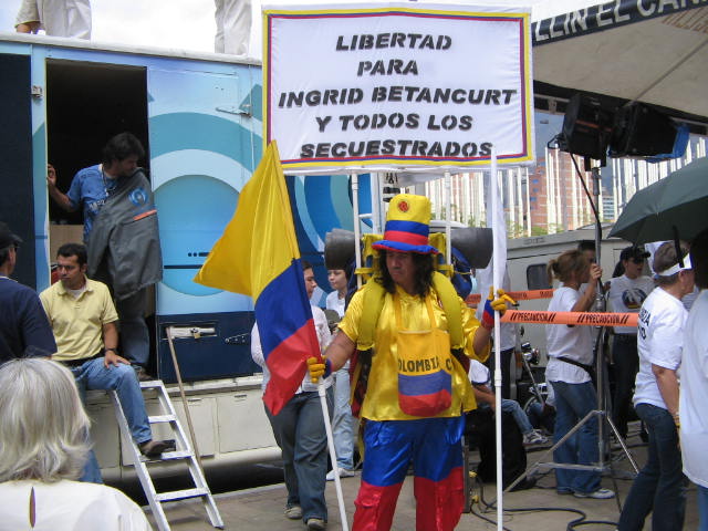 a person in costume holds a sign near some people