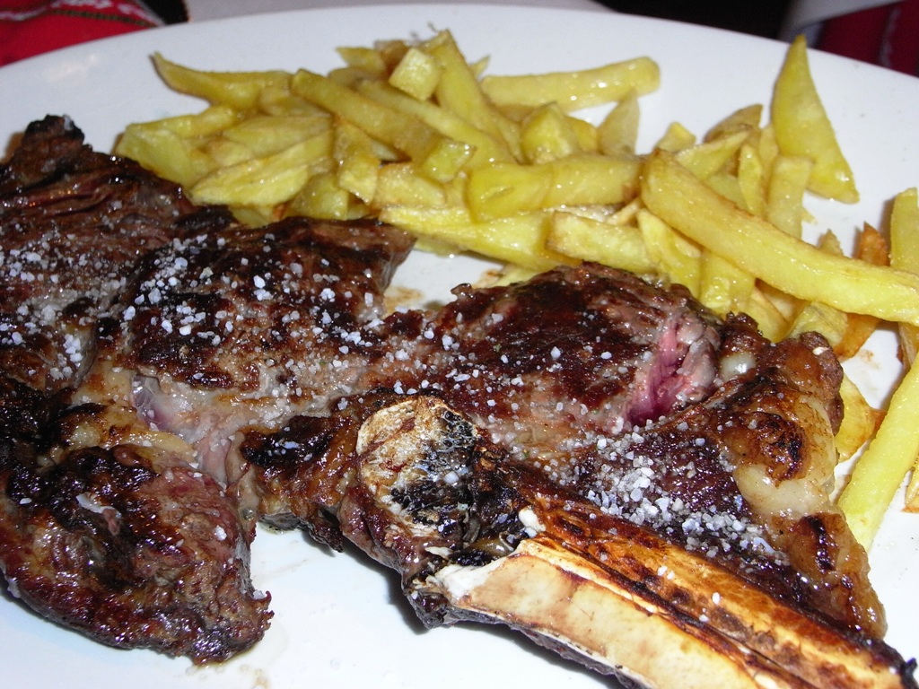 steak with fries and a side dish of french fries
