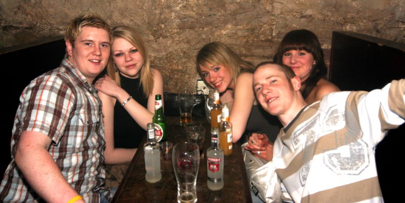 five people at a bar posing for the camera